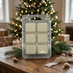 Waxmelts op een rustieke houten tafel met dennentakken en een warm verlichte kerstboom op de achtergrond